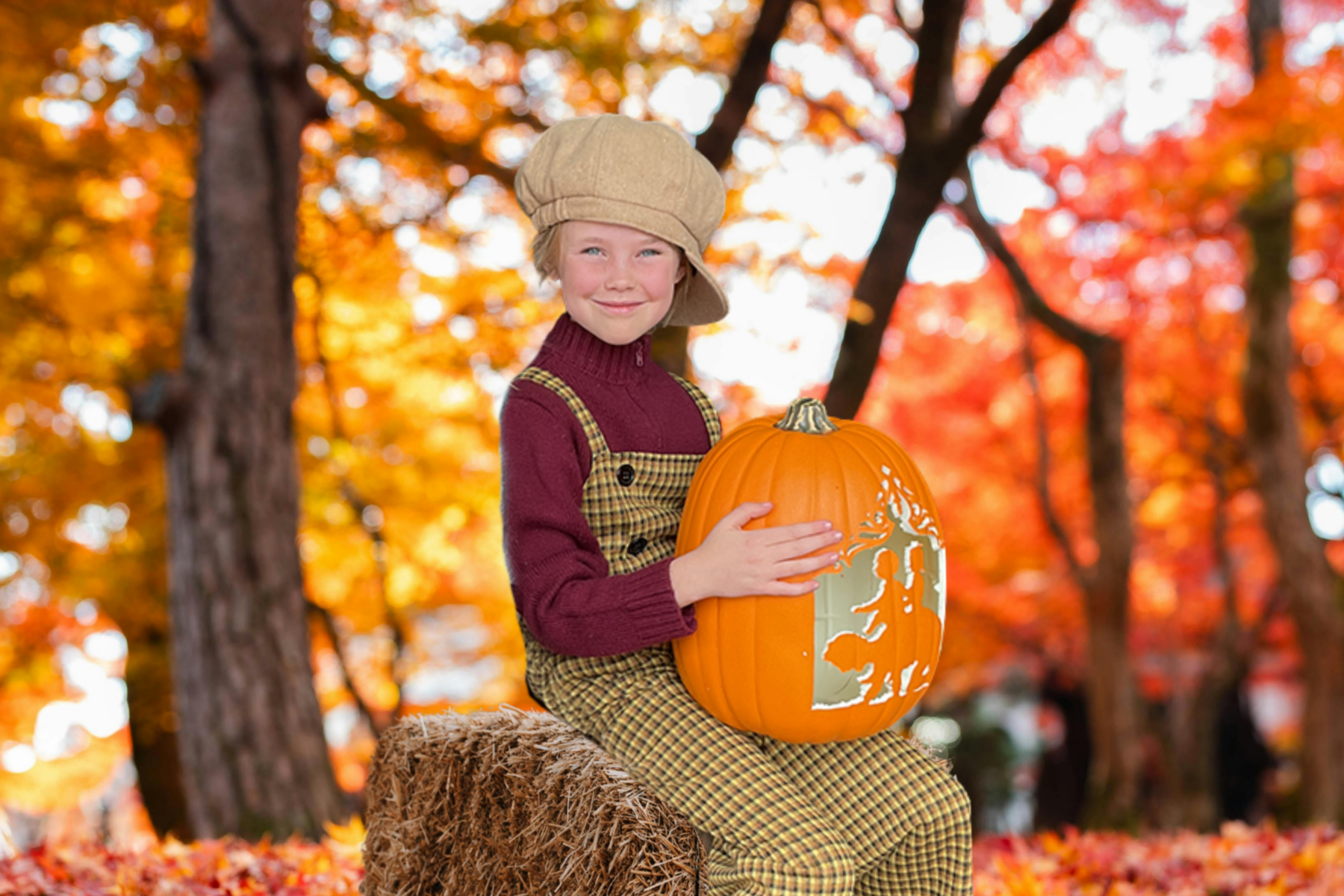 Jane Curry as the Pumpkin Kid, seated on a hay bale and holding a carved pumpkin amid autumn leaves