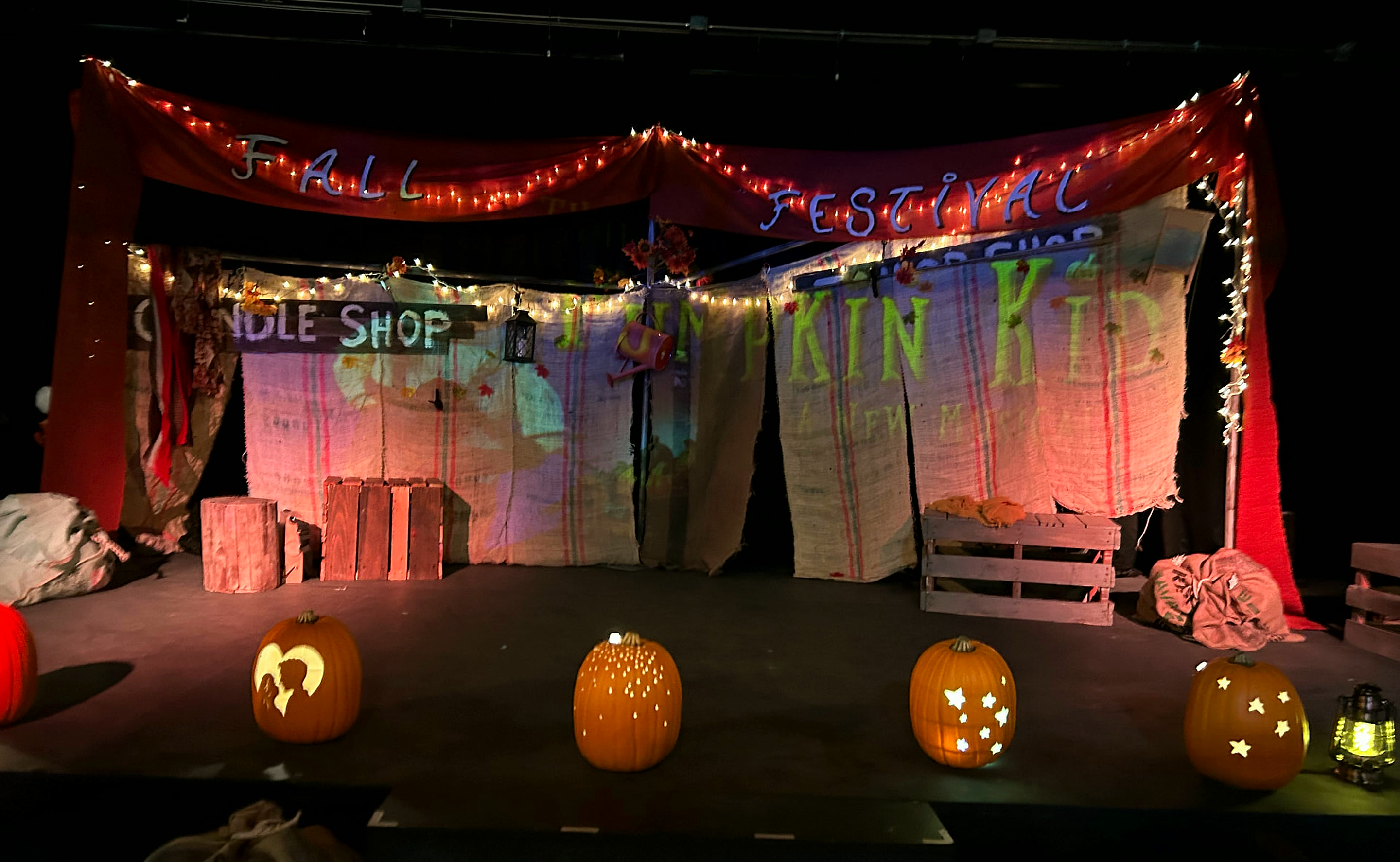 The Fall Festival set with carved, lit pumpkins lining the edge of the stage